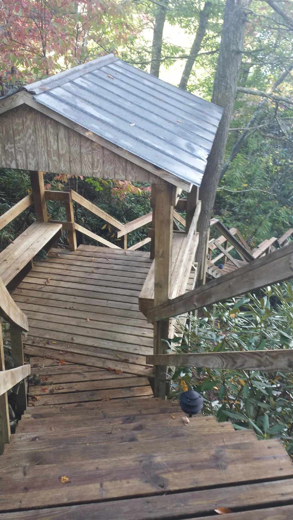 Metal roofed shelter over wooden steps on a wooded walkway — Skylight Repair & Installation work by our crew in Monmouth